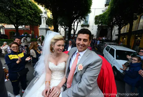 Newlyweds riding in a horse-drawn carriage through Sorrento