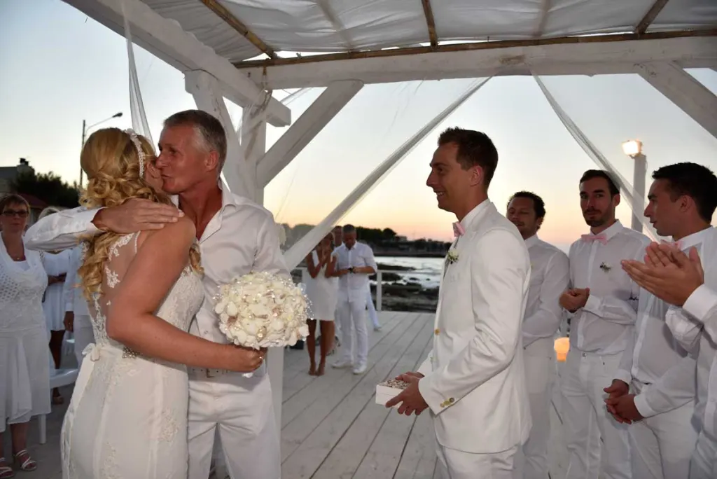 Father kissing the bride at her beach wedding in Puglia